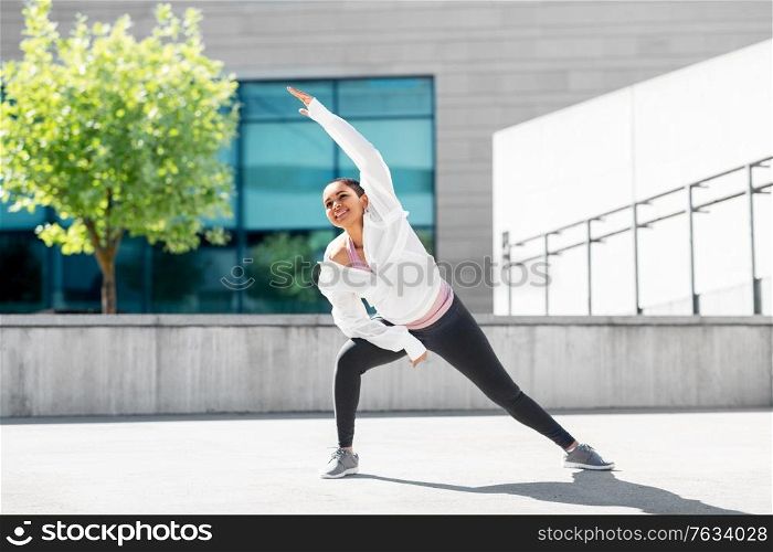 fitness, sport and healthy lifestyle concept - happy smiling young african american woman doing sports outdoors. african american woman doing sports outdoors