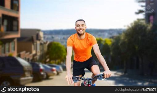 fitness, sport and healthy lifestyle concept - happy young man riding bicycle over san francisco city background. happy man riding bicycle over san francisco city. happy man riding bicycle over san francisco city
