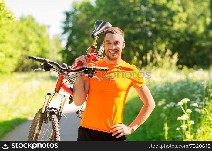 fitness, sport and healthy lifestyle concept - happy young man with bicycle outdoors in summer. happy young man with bicycle outdoors in summer