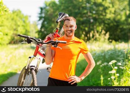 fitness, sport and healthy lifestyle concept - happy young man with bicycle outdoors in summer. happy young man with bicycle outdoors in summer