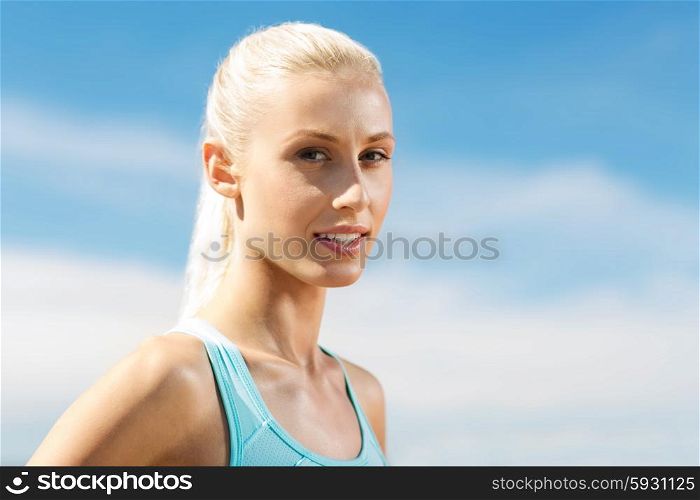fitness, sport and healthy lifestyle concept - happy young sporty woman outside