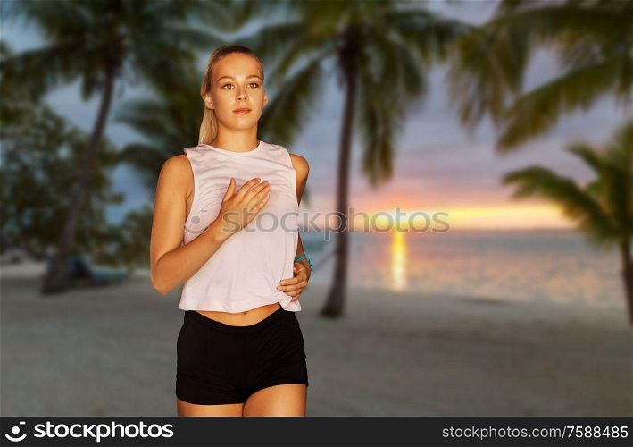 fitness, sport and healthy lifestyle concept - happy young woman running over tropical beach on background. happy young woman running along tropical beach