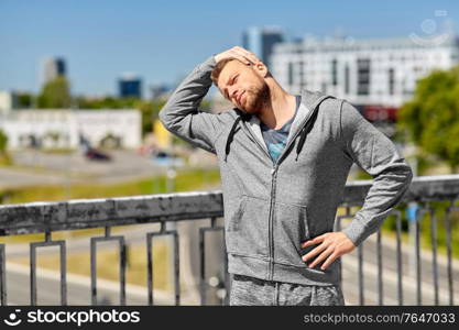 fitness, sport and healthy lifestyle concept - man stretching neck on bridge. man stretching neck on bridge