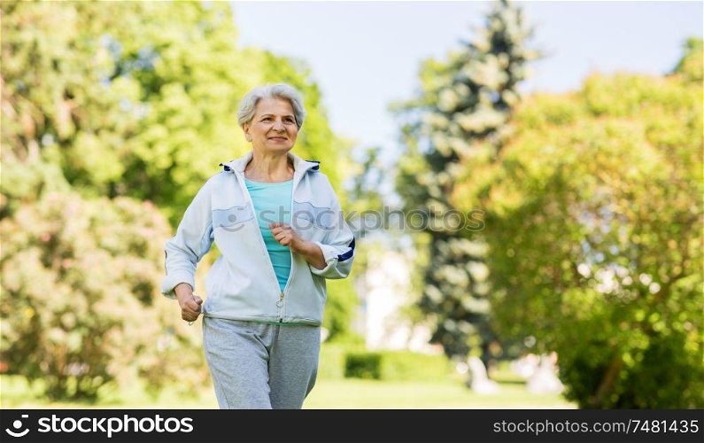 fitness, sport and healthy lifestyle concept - senior woman running along summer park. senior woman running along summer park