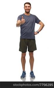 fitness, sport and healthy lifestyle concept - smiling man in sports clothes with smart watch or tracker showing thumbs up over white background. smiling man with smart watch or fitness tracker