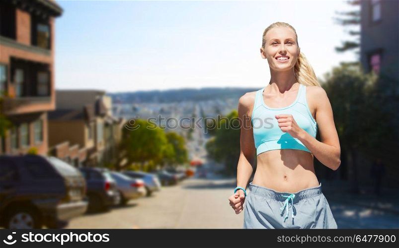 fitness, sport and healthy lifestyle concept - smiling woman running over san francisco city background. smiling woman running at san francisco city. smiling woman running at san francisco city