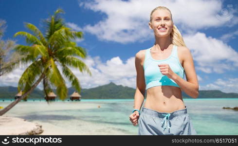 fitness, sport and healthy lifestyle concept - smiling woman running over tropical beach background in french polynesia. smiling woman running at summer. smiling woman running at summer