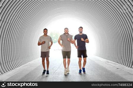 fitness, sport and healthy lifestyle concept - smiling young men or male friends running outdoors. young men or male friends running outdoors