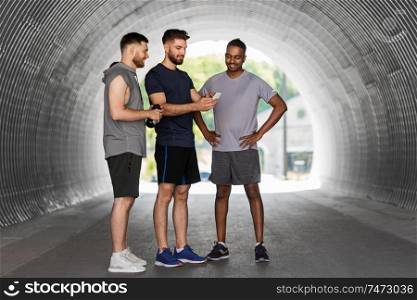 fitness, sport and healthy lifestyle concept - smiling young men or male friends with smartphone outdoors. sporty men or friends with smartphone outdoors