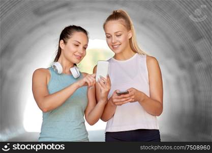 fitness, sport and healthy lifestyle concept - smiling young women or female friends with smartphones. women or female friends with smartphones