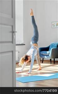 fitness, sport and healthy lifestyle concept - woman doing yoga exercise at home or at studio. woman doing yoga exercise on window sill at studio