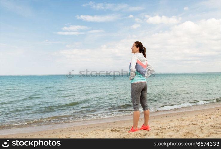 fitness, sport and healthy lifestyle concept - woman in sports clothes on beach. woman in sports clothes on beach