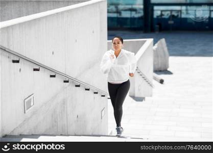 fitness, sport and healthy lifestyle concept - young african american woman running upstairs outdoors. african american woman running upstairs outdoors