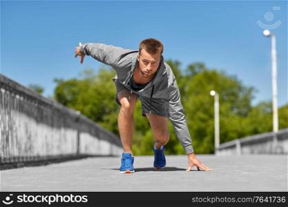 fitness, sport and healthy lifestyle concept - young man running across city bridge. young man running across city bridge