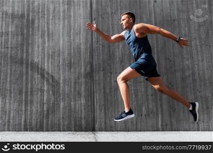 fitness, sport and healthy lifestyle concept - young man running outdoors. young man running outdoors