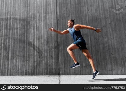 fitness, sport and healthy lifestyle concept - young man running outdoors. young man running outdoors