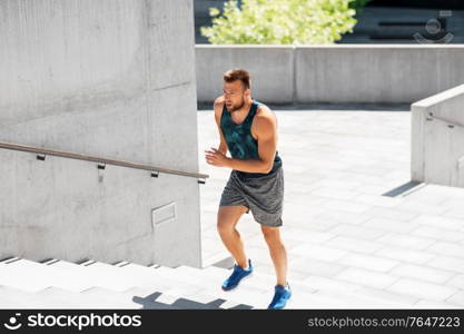 fitness, sport and healthy lifestyle concept - young man running upstairs. young man running upstairs