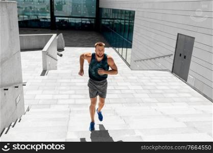 fitness, sport and healthy lifestyle concept - young man running upstairs. young man running upstairs