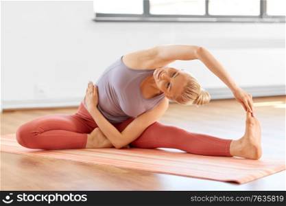 fitness, sport and healthy lifestyle concept - young woman doing yoga and side bend pose at home. woman doing yoga and side bend pose at home