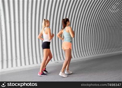 fitness, sport and healthy lifestyle concept - young women or female friends running outdoors. young women or female friends running outdoors