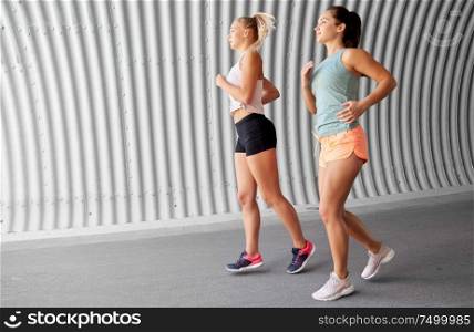 fitness, sport and healthy lifestyle concept - young women or female friends running outdoors. young women or female friends running outdoors