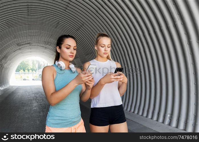 fitness, sport and healthy lifestyle concept - young women or female friends with smartphones. women or female friends with smartphones