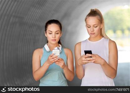 fitness, sport and healthy lifestyle concept - young women or female friends with smartphones. women or female friends with smartphones