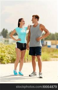 fitness, sport and lifestyle concept - happy couple in sports clothes outdoors. happy couple in sports clothes outdoors