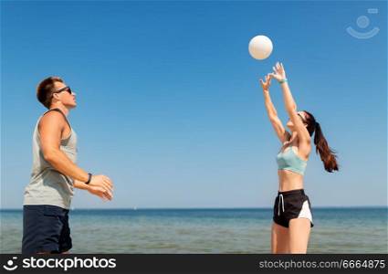 fitness, sport and lifestyle concept - happy couple with ball playing volleyball on summer beach. happy couple playing volleyball on summer beach