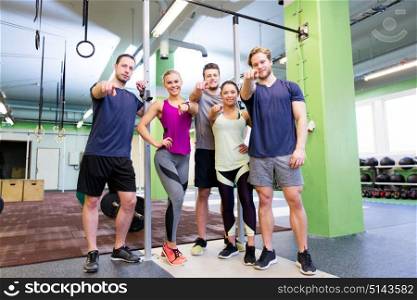 fitness, sport and people concept - group of happy friends pointing fingers at you in gym. happy friends pointing fingers at you in gym