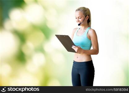 fitness, sport and people concept - happy woman sports trainer with microphone and clipboard over green natural background