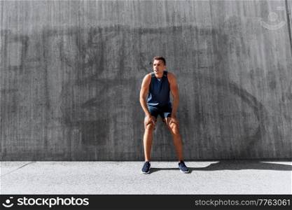fitness, sport and people concept -young tired man outdoors. tired young man doing sports outdoors