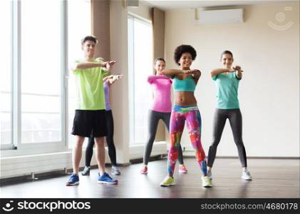 fitness, sport, dance and healthy lifestyle concept - group of smiling people with coach dancing in gym or studio