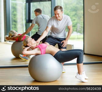 fitness, sport, exercising and diet concept - smiling young woman and personal trainer in gym