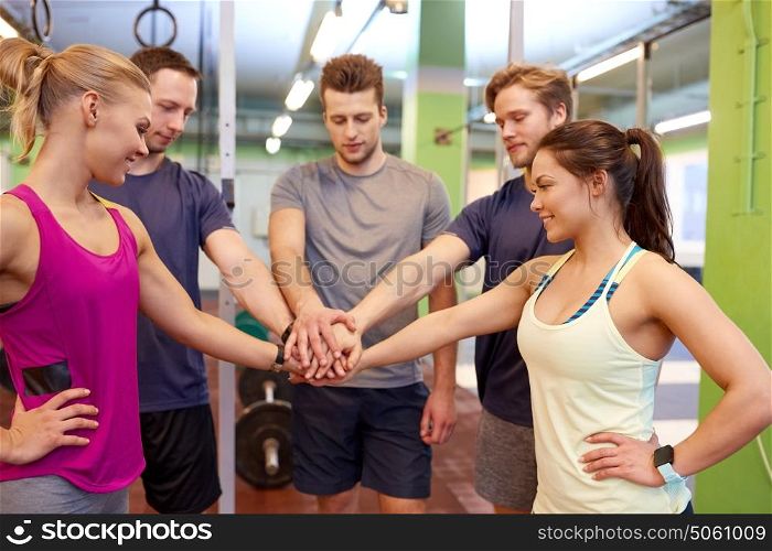 fitness, sport, exercising and healthy lifestyle concept - group of happy people holding hands together in gym. group of friends holding hands together in gym