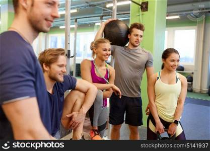 fitness, sport, exercising and healthy lifestyle concept - group of happy people with skipping rope, medicine ball and kettlebell in gym. group of friends with sports equipment in gym