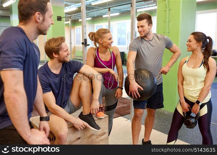 fitness, sport, exercising and healthy lifestyle concept - group of happy people with skipping rope, medicine ball and kettlebell in gym. group of friends with sports equipment in gym