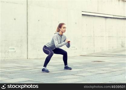 fitness, sport, exercising and healthy lifestyle concept - woman doing squats outdoors. woman doing squats and exercising outdoors