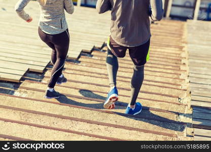 fitness, sport, exercising and lifestyle concept - close up of couple running downstairs on stadium. close up of couple running downstairs on stadium
