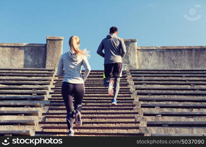 fitness, sport, exercising and lifestyle concept - couple running upstairs on stadium. couple running upstairs on stadium