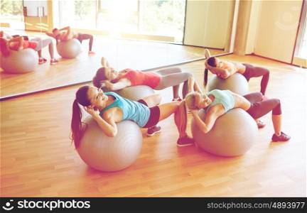 fitness, sport, exercising and lifestyle concept - group of happy women with exercise balls in gym
