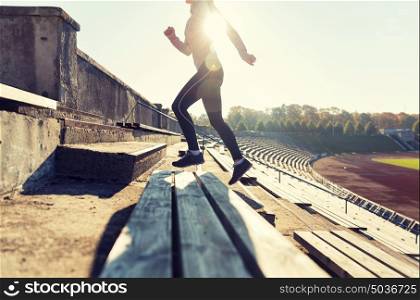 fitness, sport, exercising and people concept - close up of young woman running upstairs on stadium. close up of woman running upstairs on stadium