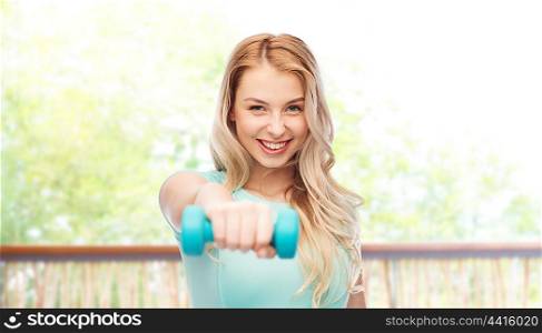fitness, sport, exercising and people concept - smiling beautiful sporty woman with dumbbell over natural view from terrace background