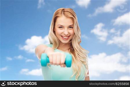 fitness, sport, exercising and people concept - smiling beautiful sporty woman with dumbbell over blue sky and clouds background