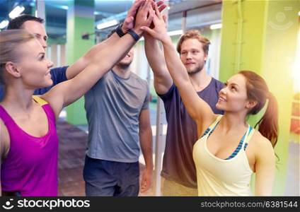 fitness, sport, exercising, gesture and people concept - group of happy friends making high five in gym. group of happy friends making high five in gym