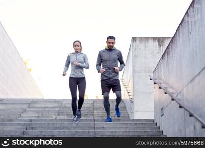 fitness, sport, exercising, people and lifestyle concept - couple walking downstairs on stadium