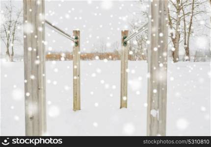 fitness, sport, exercising, training and equipment concept - parallel bars outdoors in winter. parallel bars outdoors in winter