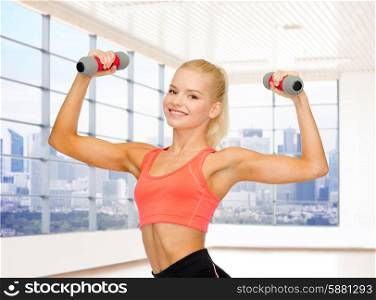 fitness, sport, fitness and people concept - smiling woman with light weight dumbbells flexing biceps over gym or home background