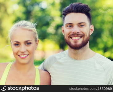 fitness, sport, friendship and healthy lifestyle concept - group of happy teenage friends or sportsmen couple hugging outdoors