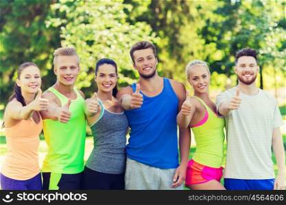 fitness, sport, friendship and healthy lifestyle concept - group of happy teenage friends or sportsmen showing thumbs up outdoors